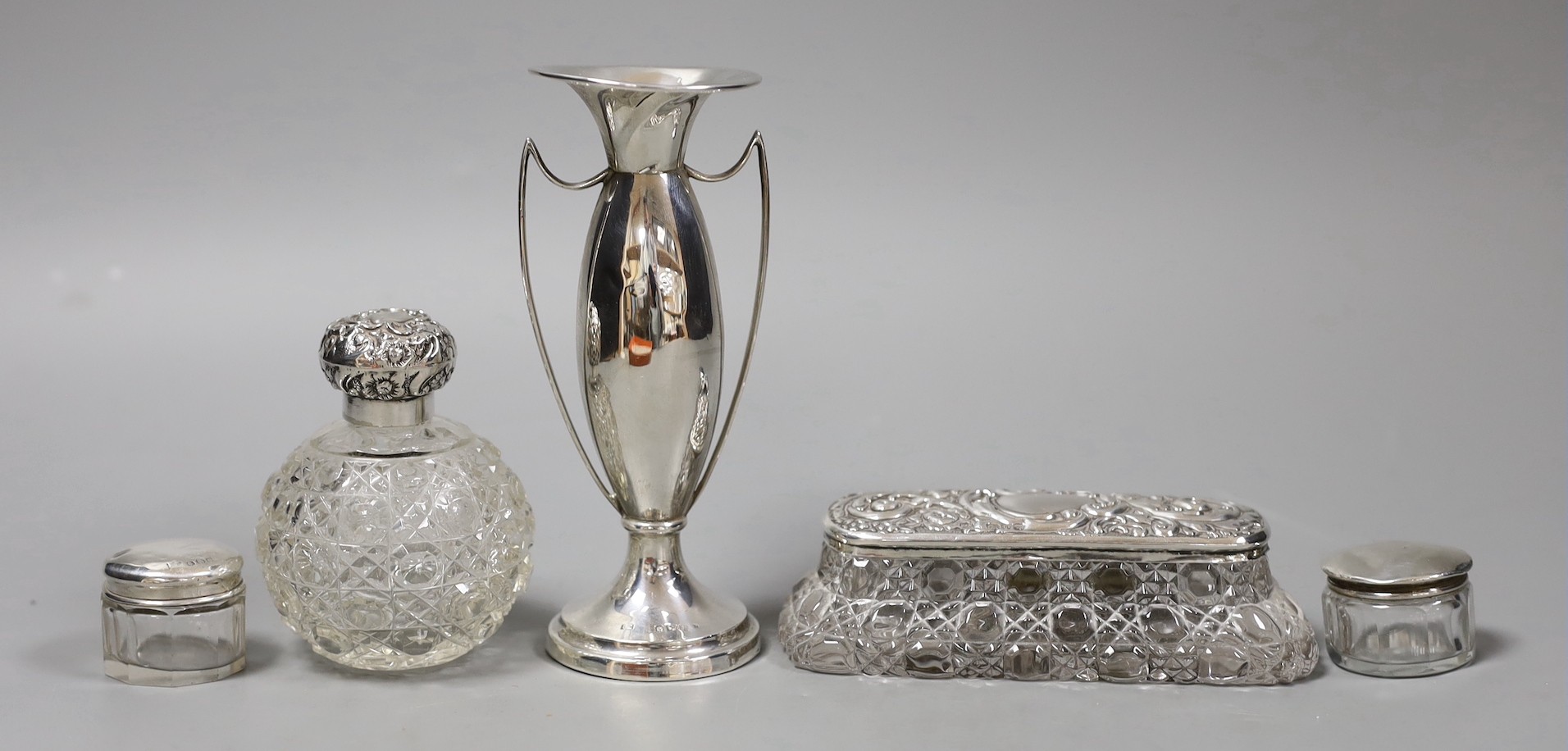 An Edwardian silver two handled posy vase, 13.7cm, a silver mounted glass scent bottle and three similar toilet jars.